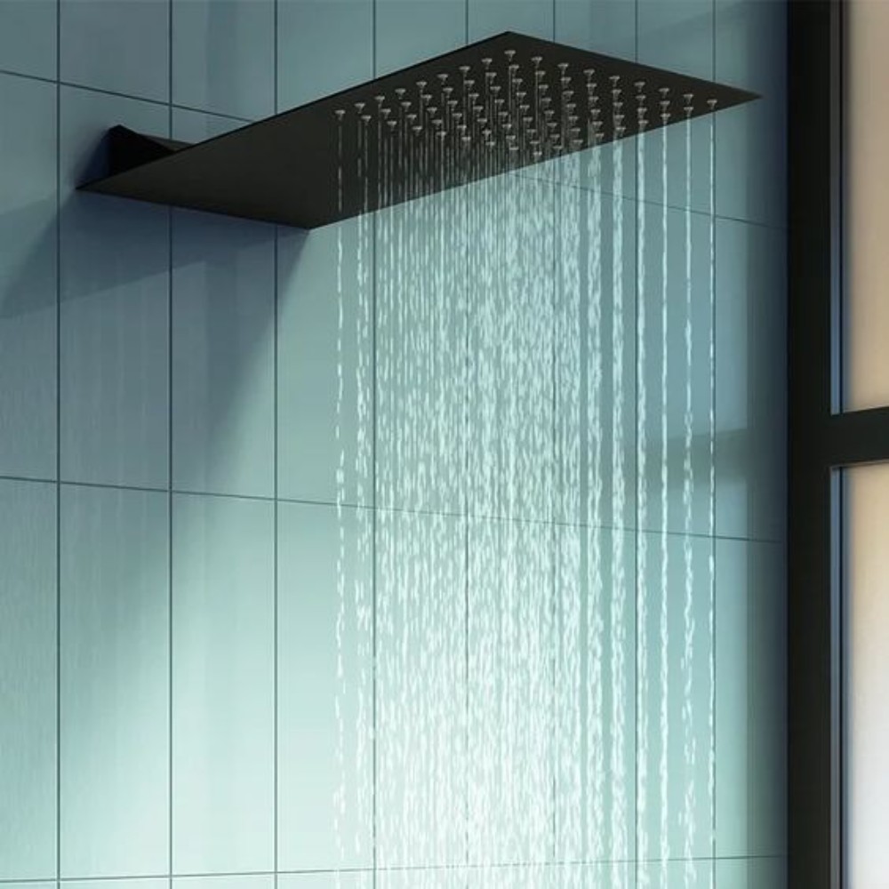 Close view of black shower head with water flow in a modern shower space